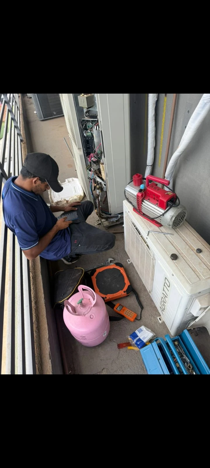 Profissional da Eletrogelo trabalhando em equipamento de ar-condicionado com ferramentas